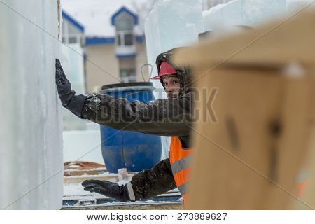 Worker Fitter In A Protective Helmet And Reflective Vest On The Working Meast