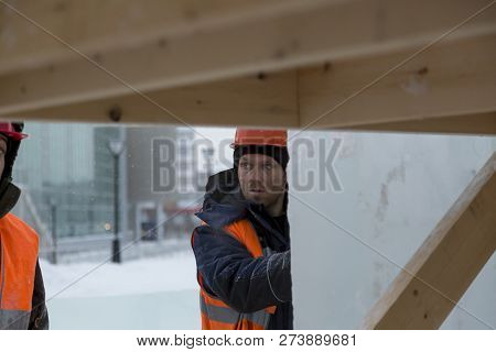 Worker Fitter In A Protective Helmet And Reflective Vest On The Working Meast