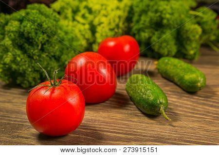 Tomatoes And Cucumbers On An Old Wooden Table. The Concept Of A Healthy Diet