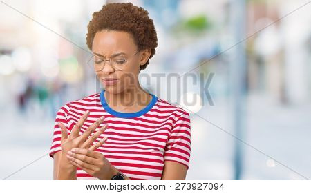 Beautiful young african american woman wearing glasses over isolated background Suffering pain on hands and fingers, arthritis inflammation