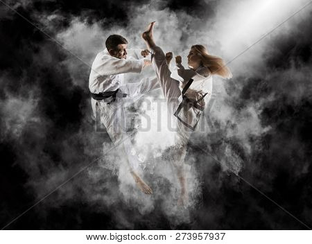 Martial arts masters, karate practice. Smoke background