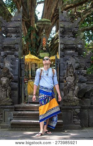 Traveler Man In Empty Temple With Traditional Sarung. Holy Place In Bali Indonesia. Religion, Cultur
