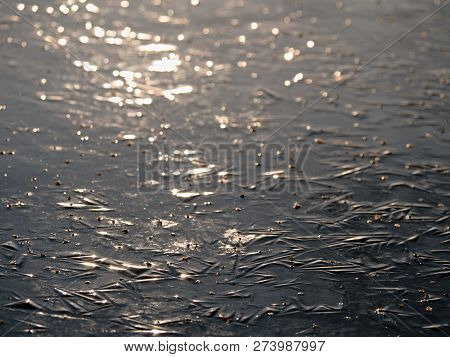 Abstract Surface Of Frozen Lake. Frozen Air In Arctic Ice. Colorful Piece Of Ice With Sun Rays Refle