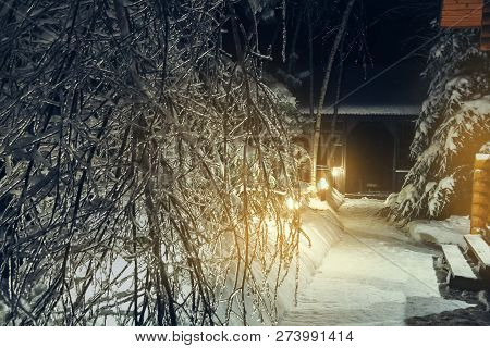 Winter Night Landscape. The Courtyard Of The Country House After The Icy Rain. Snow-covered Bushes A