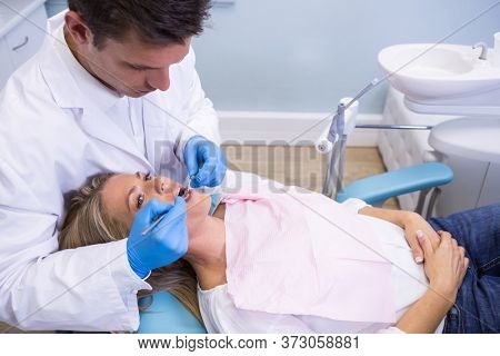 High angle view of dentist examining patient at clinic