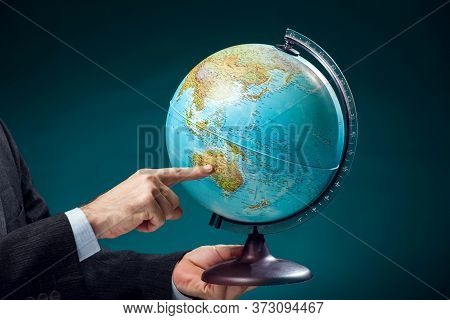 A Man In Suit Holding Globe And Pointing At Australia Continent. Business, Education And Travel Conc