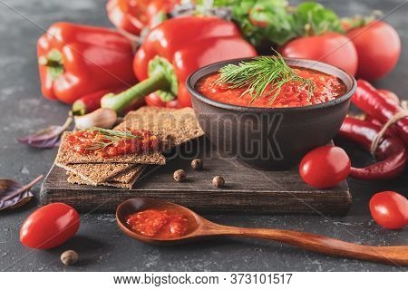 Balkan Sauce Ajvar In A Clay Bowl On A Wooden Table, Close-up. Serbian Native, Traditional Food.