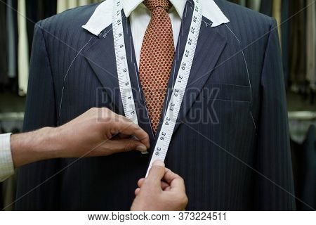 Tailor measuring business man for suit mid section close up