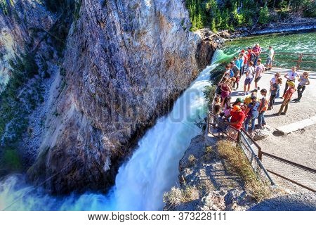 Wyoming, Usa - Aug. 27, 2019: Visitors Stand At The Brink Of Lower Falls At Yellowstone National Par