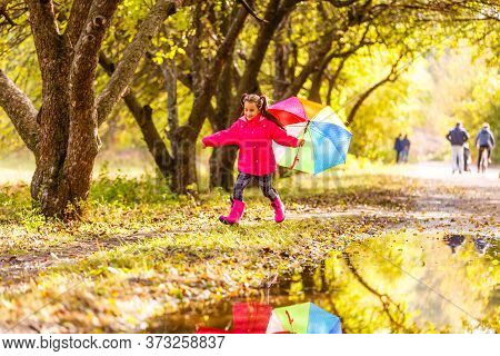 Adorable Toddler Girl With Colorful Umbrella Outdoors At Autumn Rainy Day