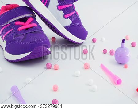 Close Up View Of Violet Pink Childrens Sneakers With Pink And White Balls And Felt-tip Pens At Peach