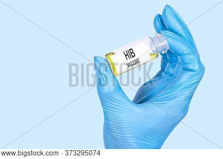 Hib Vaccine Text Is Written On A Vial Whose Ampoule Is Held By A Hand In A Medical Disposable Glove.