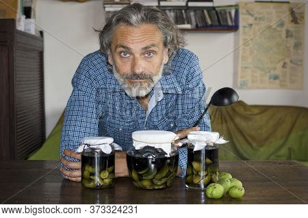 Man Posing With Nocino Jars Italian Liqueur