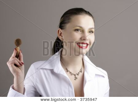 Jeune femme avec le pinceau de maquillage