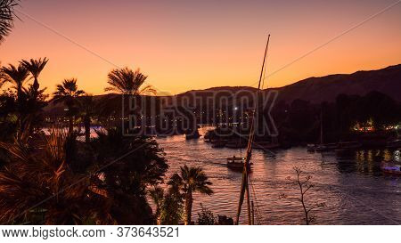 Nile River Bank In Egypt Sunset Orange Sky And Palm Tree With Sand Dessert Slope