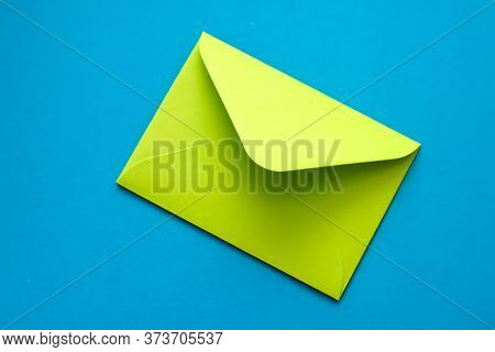 Green Envelope On A Blue Background. Postal Envelope. Love Letter. Colorful Photo Of The Postal Enve