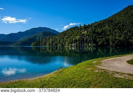 Beautiful View Of Lake Ledro With Pontoon Boats, Villages And The Daily Life Of A Mountain Lake In T