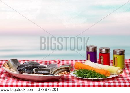 Close-up Of Fresh Cleaned Pieces Of Raw Eel Fish On A Porcelain Plate And Necessary Ingredients Like