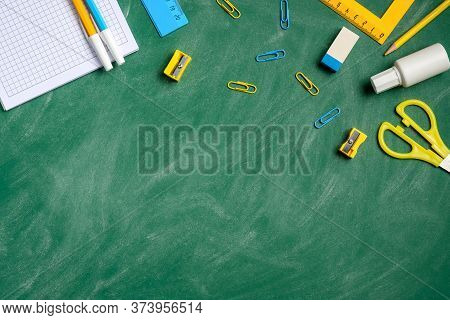 Flat Lay School Stationery On A Green Chalkboard Background. Back To School Education Concept. Top V