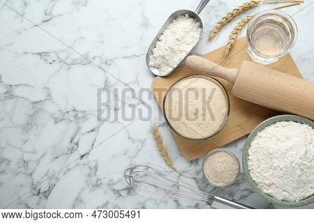 Leaven, Flour, Ears Of Wheat, Rolling Pin, Whisk And Water On White Marble Table, Flat Lay. Space Fo