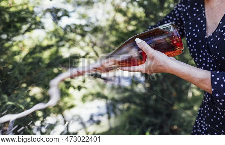 Young Woman Opens A Bottle Of Sparkling Wine By The Knife. Sabrage. Close Up.