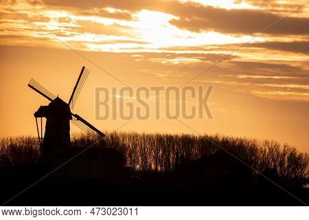 Early In The Morning There Is A Beautiful Windmill Whit The Sun Rising In The Sky