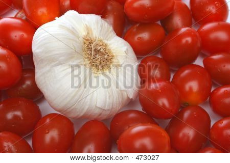 Aglio circondato da pomodori ciliegino