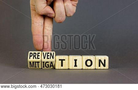 Prevention Or Mitigation Symbol. Businessman Turns Cubes And Changes The Concept Word Mitigation To 