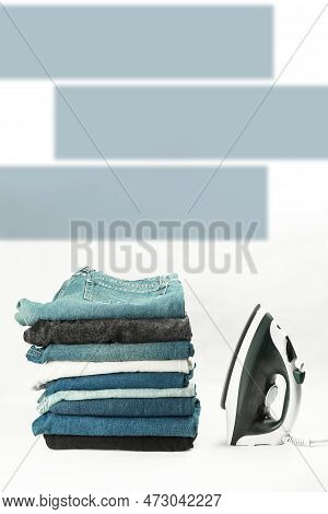 Clean Things Lie On A Pile On A White Background. Steam Iron And Clothes Against White Background