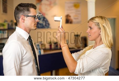 Ottico o optometrista misura la distanza degli occhi di un cliente
