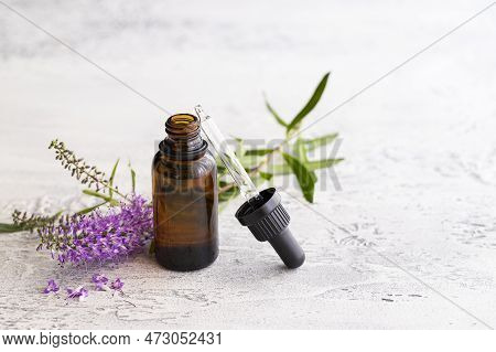 Essential Lavender Oil In Glass Bottle On Light Concrete Background With Copy Space. Aromatherapy An