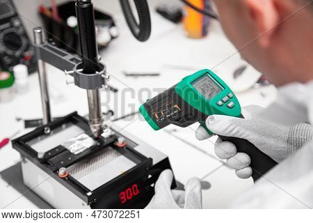 The Master Measures The Temperature Of The Microchip At The Soldering Station With A Laser Thermomet