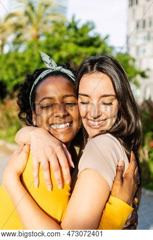 Vertical Portrait Of Candid Happy Multiracial Best Women Friends Embracing Outdoors. Close Up View O