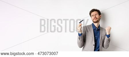 Excited Successful Businessman Dancing With Plastic Credit Card, Raising Fist Pumps And Smiling Deli