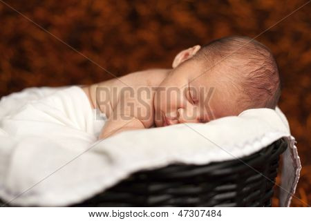 Close-up van schattige babyjongen slapen in een mand