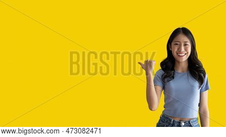Asian woman pointing finger inviting click here, It is recommended to follow this direction or click