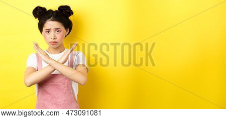 Sad Girl Begging To Stop, Frowning Uspet And Showing Cross Sign, Say No, Standing Gloomy On Yellow B