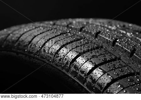 Wet Summer Tire On A Black Background. Driving On A Slippery Road.