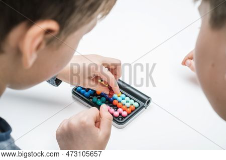 Close Up Rearview Of Boys Playing Educational, Strategy Board Game With Black Field And Colorful Bal