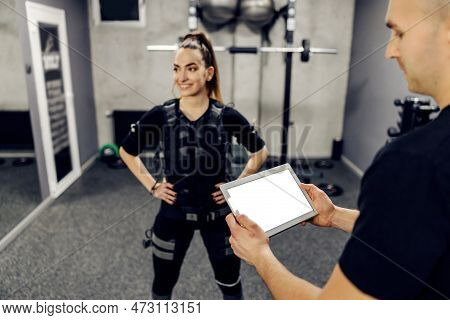 The Concept Of Ems Training, Electrical Muscle Stimulation. Woman In An Ems Suit Stands In The Gym I