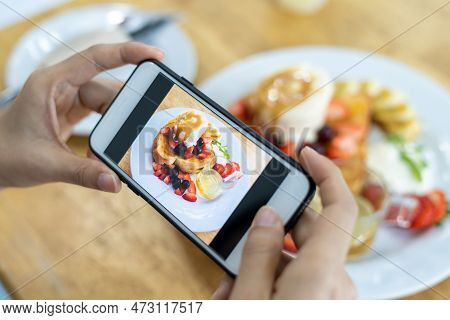 Restaurant Owner Takes A Picture Of The Food On The Table With A Smartphone To Post On A Website. On