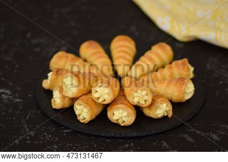 Rolls Filled With Vanilla Cream On The Black Plate.
