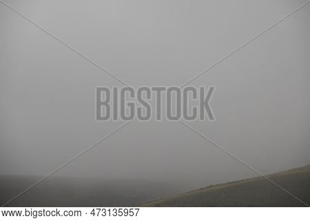 A Foggy Field, A Lush Green Hillside, Fog Day In The Mountains.