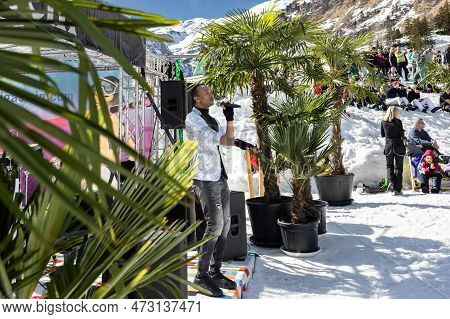 Austria, Sportgastein - March 18, 2023: Event Palmen Auf Den Almen, Musician Sings Against The Backd