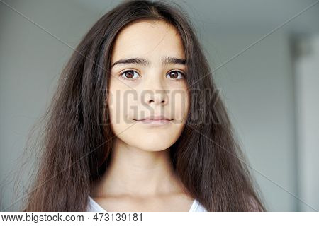 Serious Beautiful Preteen 12s Girl Pose Indoors, Having Long Brunette Hair Smile Looking At Camera. 