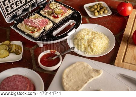 Cooking Waffles Stuffed With Sausage, Cheese. Pizza Waffle, Piffle. Open Waffle Iron With Yeast Doug