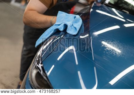 A Master In A Car Service Wipes A Car With A Napkin After Applying A Protective Armor Film.