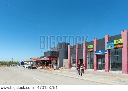 Groblershoop, South Africa - Feb 24, 2023: A Street Scene, With Businesses, People And Vehicles, In 