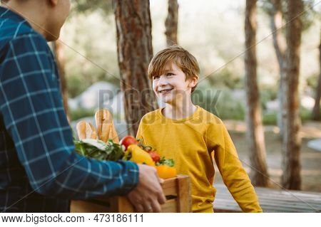 Father And Son Farmers Holding A Wooden Crate With Supplies Groceries. Man Male Dad And His Should K