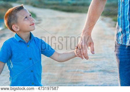 Hands Of A Happy Child And Parent In Nature In A Park By The Road